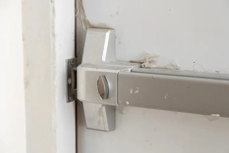 Nahaufnahme eines mechanischen Panzerriegels aus Metall an einer Tür mit sichtbaren Gebrauchsspuren